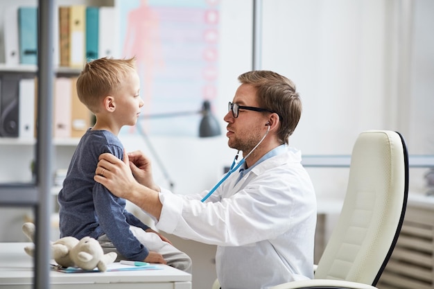 Doctor escuchando los pulmones de los niños con estetoscopio