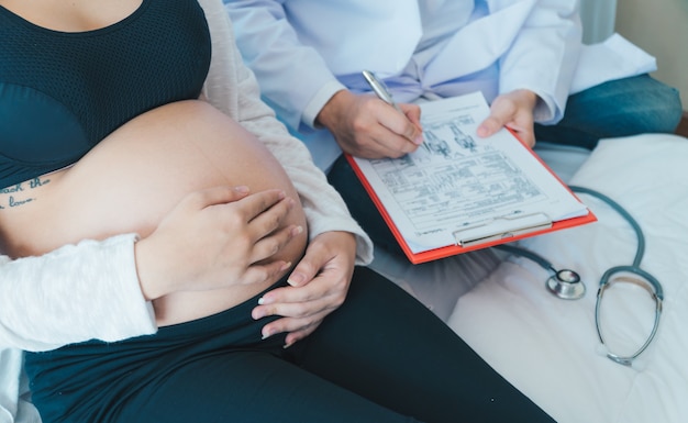 El doctor está diagnosticando mujeres embarazadas.