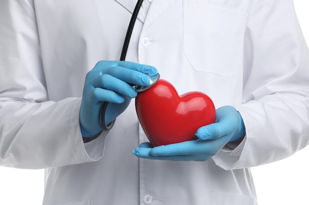 Doctor con estetoscopio y corazón rojo aislado en primer plano blanco