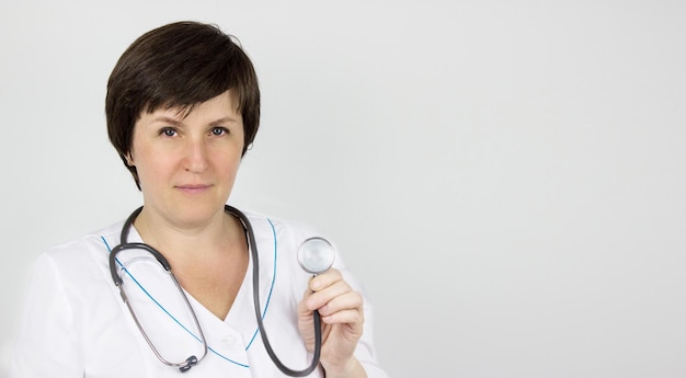 Doctor con un estetoscopio en la mano. Médico o médico en uniforme de bata blanca con estetoscopio.