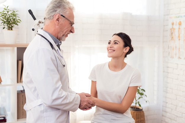 Doctor con el estetoscopio con el paciente femenino en oficina.