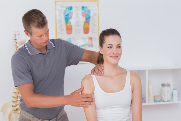 Doctor estirando el brazo de la mujer