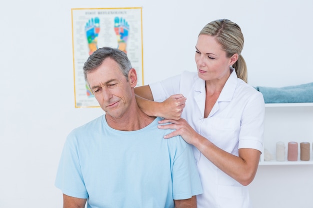 Doctor estirando su cuello paciente