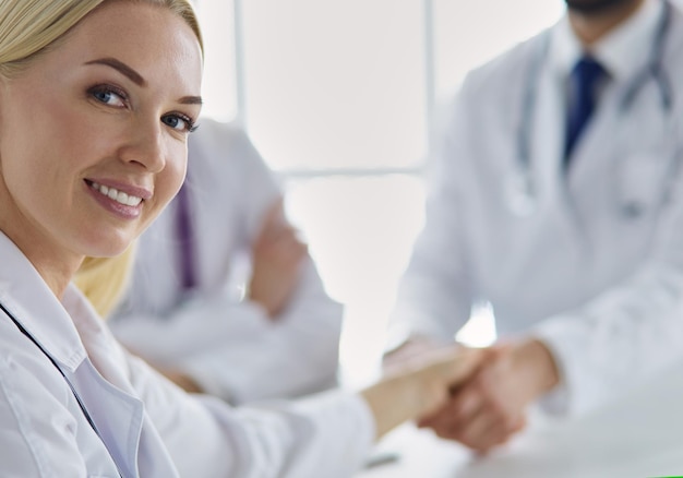 Doctor estrechando la mano de un paciente masculino en la oficina