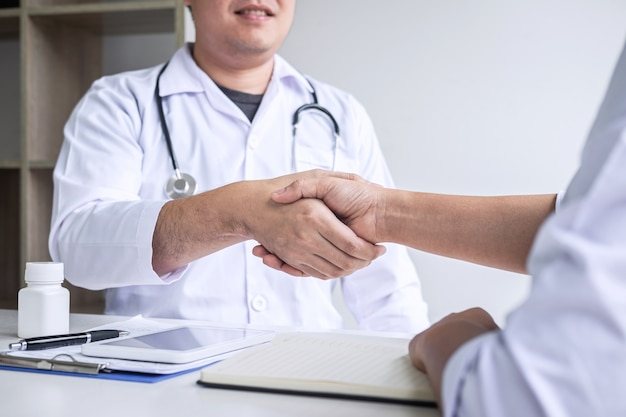 Foto doctor estrechándole la mano a un paciente después de recomendar un tratamiento de enfermedad