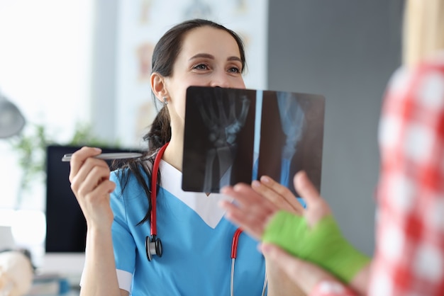 Doctor examina una radiografía de la mano del paciente