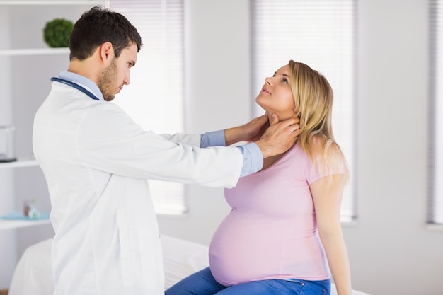 Doctor examinando el cuello del paciente embarazada