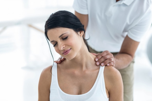 Doctor examinando y dando fisioterapia a una mujer embarazada