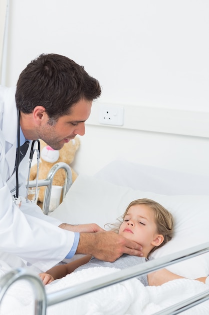 Doctor examinando las glándulas tiroides de la niña enferma