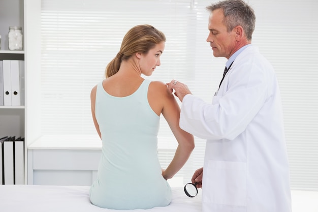 Doctor examinando el hombro de un paciente