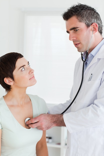 Foto doctor examinando a una mujer encantadora