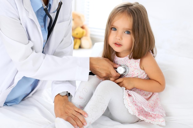 Doctor examinando a una niña con estetoscopio