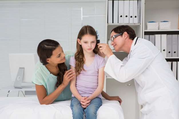 Doctor examinando a niña con su madre