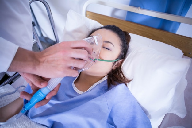 Doctor examinando a un paciente en cama en el hospital