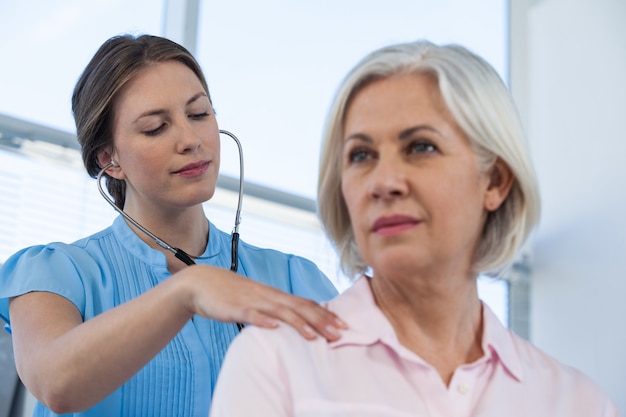 Doctor examinando a un paciente con estetoscopio