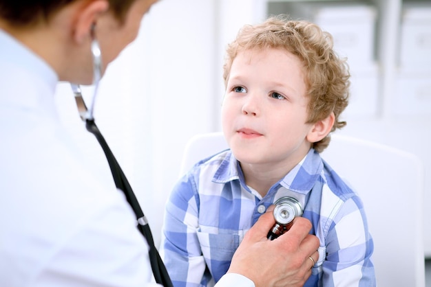 Doctor examinando a un paciente infantil con estetoscopio