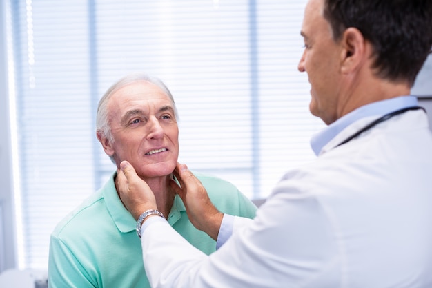 Doctor examinando pacientes mayores cuello