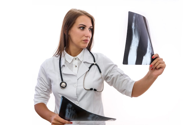 Doctor examinando rayos x. Hermosa mujer en bata médica con radiografía de pacientes aislado en blanco