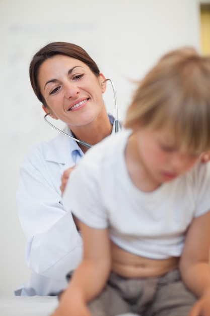 Doctor examinando la respiración de un niño con un estetoscopio