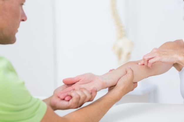 Doctor examinando su brazo de pacientes