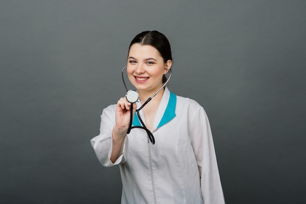 Doctor feliz alegre con las manos cruzadas sobre fondo gris