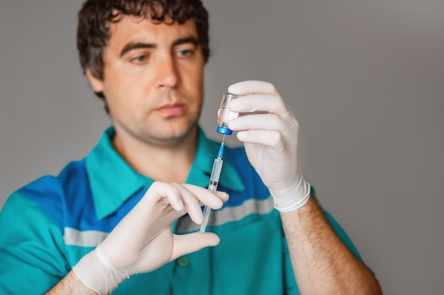 Doctor en guantes blancos con vacuna contra la gripe