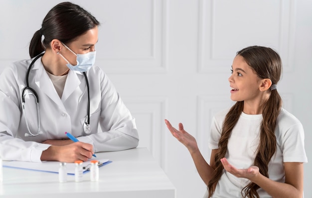 Foto doctor hablando con una niña