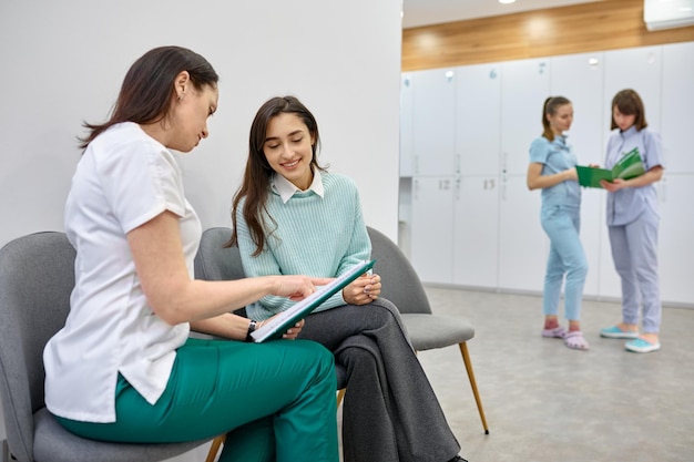 Foto doctor hablando con un paciente adolescente en el pasillo