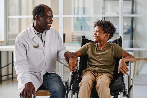 Doctor hablando con un pequeño paciente con discapacidad