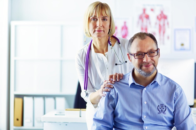 Doctor hablando con su paciente masculino en la oficina