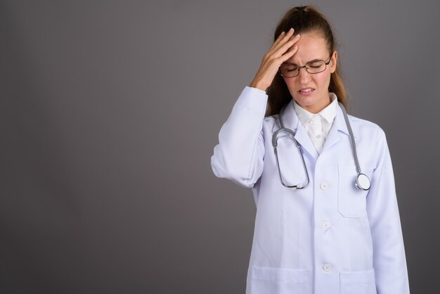 Foto doctor hermoso joven de la mujer contra fondo gris