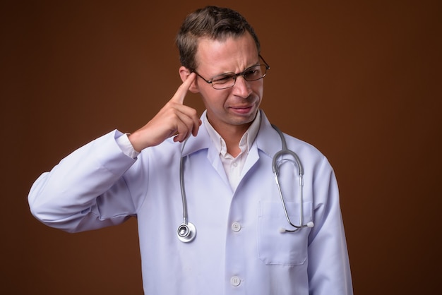 Foto doctor hombre contra la pared marrón