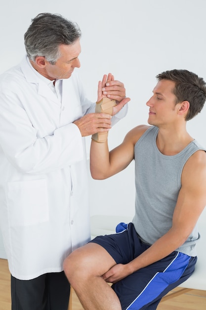 Doctor hombre examinando la mano de un paciente