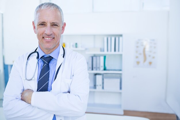 Foto doctor hombre feliz mirando a cámara con los brazos cruzados