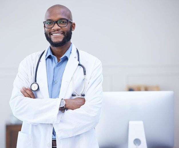 Doctor hombre negro y retrato con los brazos cruzados en un hospital con éxito en el cuidado de la salud y el bienestar Enfréntate a la felicidad y al empleado médico con un profesional africano que se siente orgulloso con la maqueta