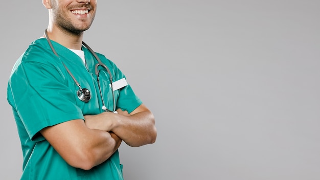 Doctor hombre sonriente con brazos cruzados y espacio de copia