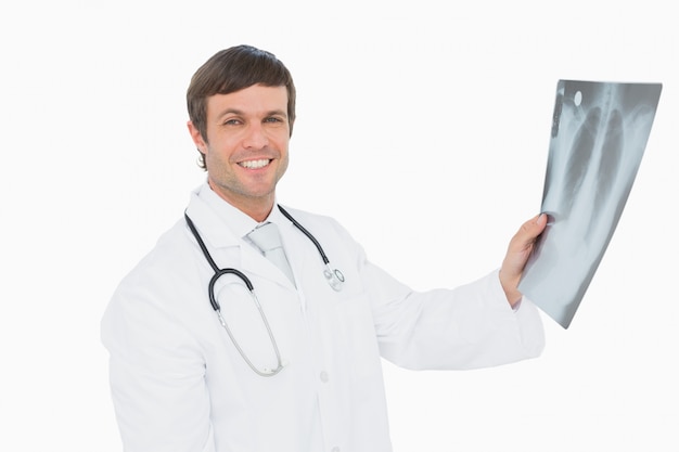Doctor hombre sonriente sosteniendo una imagen de rayos x de pulmones