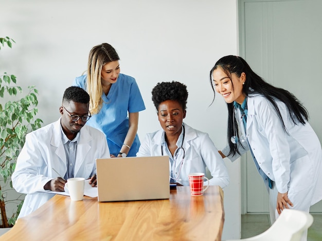 Doctor hospital médico salud medicina trabajo en equipo clínica cuidado de la salud computadora portátil equipo de atención diversidad negra unidad multirracial afroamericano asiático enfermera