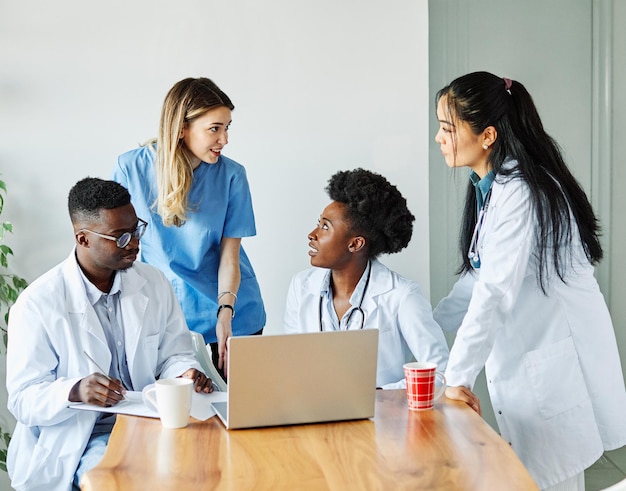 Doctor hospital médico salud medicina trabajo en equipo clínica cuidado de la salud computadora portátil equipo de atención diversidad negra unidad multirracial afroamericano asiático enfermera