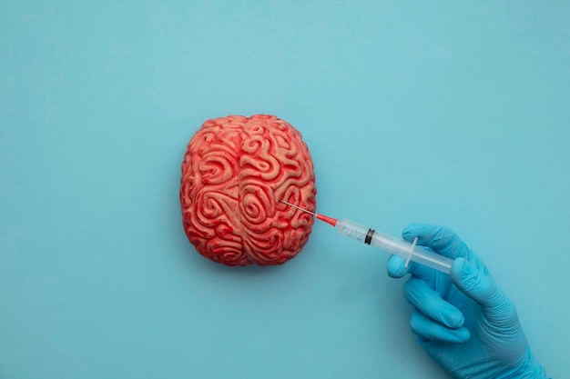 Doctor inyectando un cerebro con una jeringa concepto de enfermedad mental