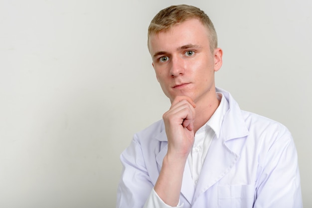 Doctor joven con cabello rubio sobre blanco