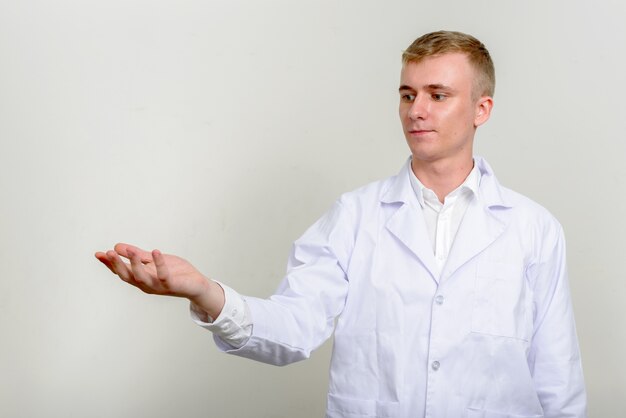 Doctor joven con cabello rubio sobre blanco