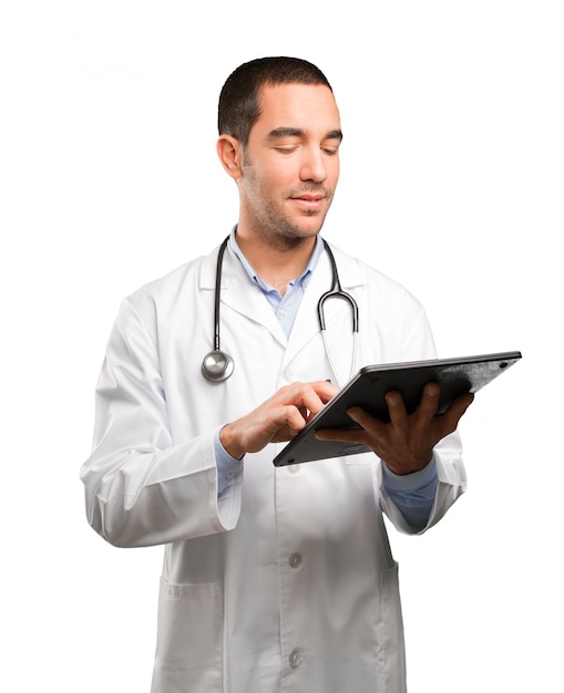Doctor joven feliz que usa una tableta