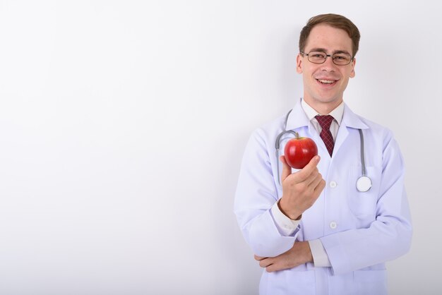 Doctor joven guapo con anteojos en la pared blanca