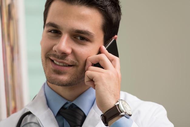 Doctor joven hablando por teléfono