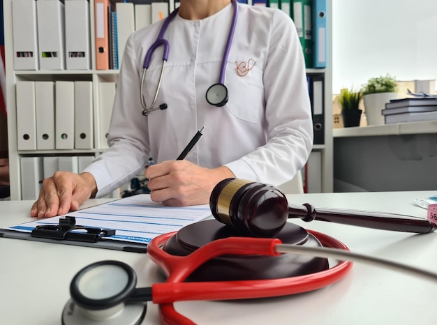 Foto el doctor llena el documento legal en la oficina en la mesa