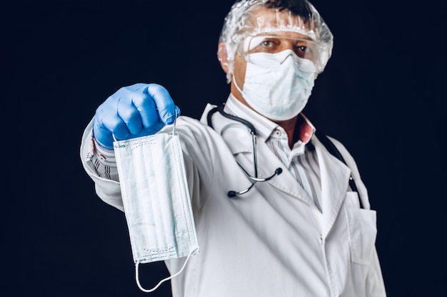 Doctor mano con una mascarilla médica para protección.