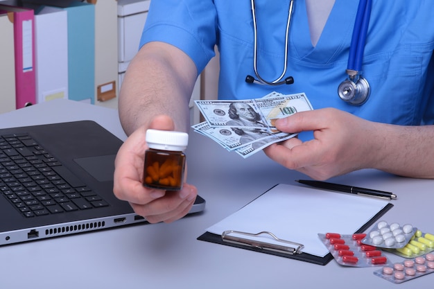 Doctor mano mostrando cajas de drogas en el escritorio de la oficina.