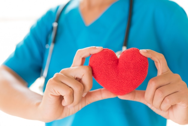 Doctor manos sosteniendo corazón rojo. Concepto de salud y médico.