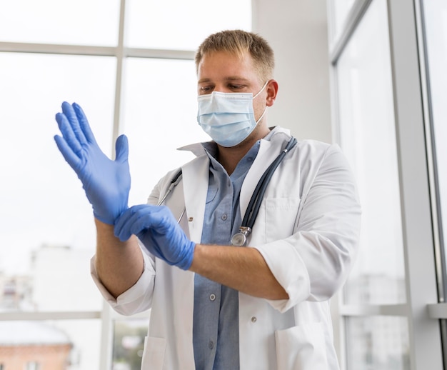 Foto doctor con mascarilla y guantes quirúrgicos